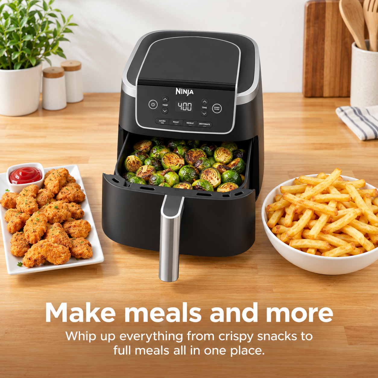 Air fryer preparing vegetables alongside fries and chicken